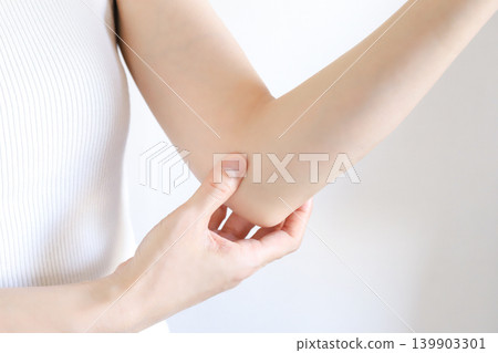 Image of a woman concerned about elbow pain Image of a woman concerned about elbow pain 139903301