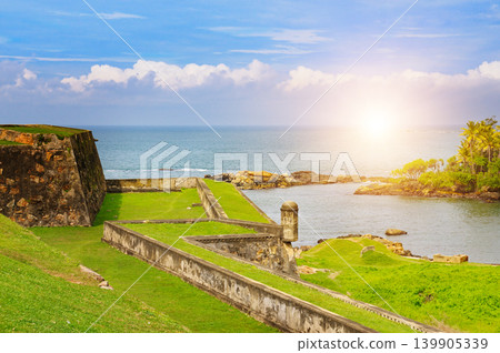Historic stone fort walls with watchtower by the tropical sea. Historic stone fort walls with watchtower by the tropical sea. 139905339