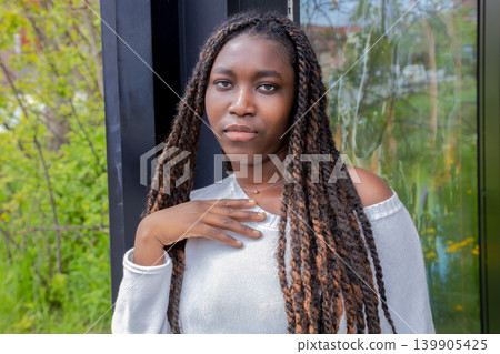 Young African woman waiting at bus stop, urban outdoor portrait Young African woman waiting at bus stop, urban outdoor portrait 139905425