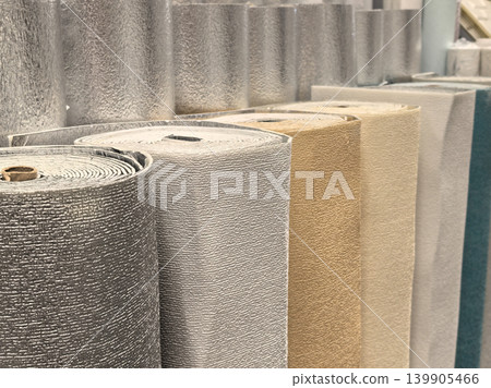 Colorful foil insulation and wallpaper rolls displayed in hardware store Colorful foil insulation and wallpaper rolls displayed in hardware store 139905466
