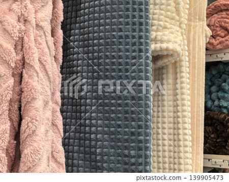 Soft plush blanket fabric texture in pink blue cream and rose colors on shelf 139905473