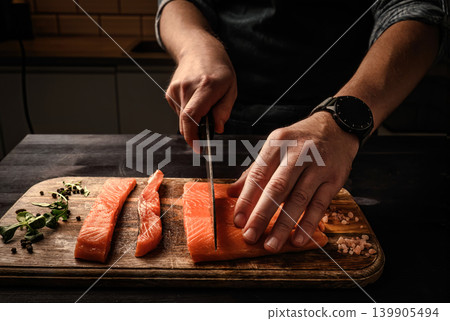 Chief cutting salmon red fish fillet on a cutting board Chief cutting salmon red fish fillet on a cutting board 139905494
