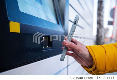 Girl Picking Up A Parcel From Parcel Automated Locker Girl Picking Up A Parcel From Parcel Automated Locker 139905541