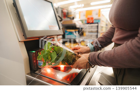 Woman Scanning Fresh Mint In Pot At Self-Service Checkout Woman Scanning Fresh Mint In Pot At Self-Service Checkout 139905544