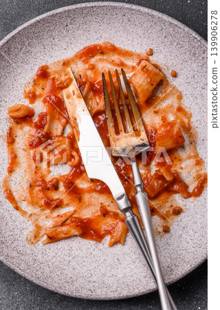A dirty plate after a meal with leftover pasta and tomato sauce, cleaning. An empty dirty plate A dirty plate after a meal with leftover pasta and tomato sauce, cleaning. An empty dirty plate 139906278