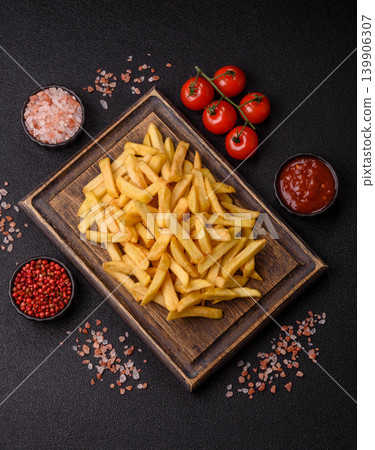 Crispy, fresh, golden French fries with salt, unhealthy takeaway food. French fries Crispy, fresh, golden French fries with salt, unhealthy takeaway food. French fries 139906307