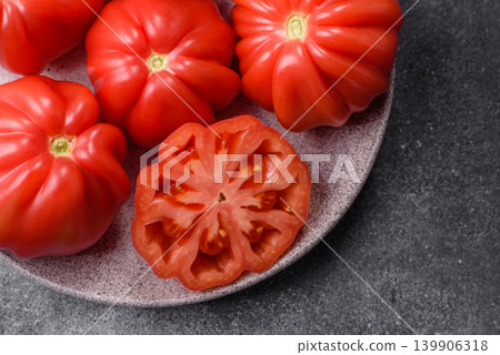 Fresh pink heirloom ribbed tomatoes as an ingredient for a lunch salad. Ribbed heirloom tomatoes Fresh pink heirloom ribbed tomatoes as an ingredient for a lunch salad. Ribbed heirloom tomatoes 139906318