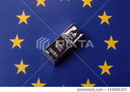 A silver bar, white metal against a backdrop of EU flag, as a concept. A silver bar A silver bar, white metal against a backdrop of EU flag, as a concept. A silver bar 139906367