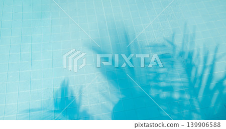 Stunning swimming pool water surface abstract palm leaf shadow sunshine tropical outdoor poolside breathtaking dreamy luminous ethereal serene tranquil relaxing background artistic pattern texture 139906588