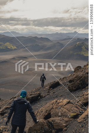 Hikers Traverse Volcanic Highlands with Moss Covered Hills in Iceland Hikers Traverse Volcanic Highlands with Moss Covered Hills in Iceland 139906688