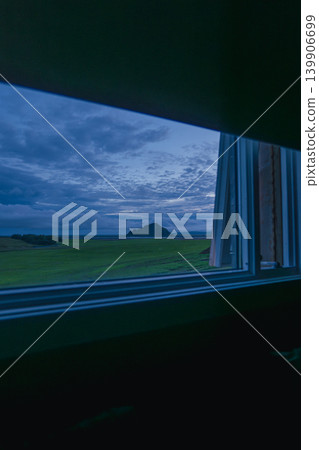 Grassy Landscape at Dusk Viewed Through an Open Window Grassy Landscape at Dusk Viewed Through an Open Window 139906699