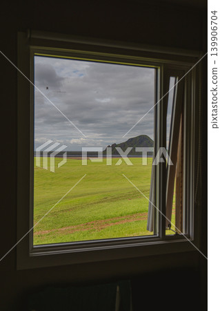 View Through a Window of Green Field, Rocky Hill, and Coastline View Through a Window of Green Field, Rocky Hill, and Coastline 139906704