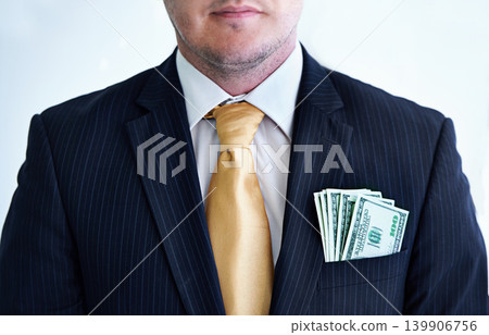 Suit, serious and businessman with money in pocket for bribe, fraud or financial scam in studio. Corruption, pay and closeup of professional male person with cash for crime by white background. Suit, serious and businessman with money in pocket for bribe, fraud or financial scam in studio. Corruption, pay and closeup of professional male person with cash for crime by white background. 139906756