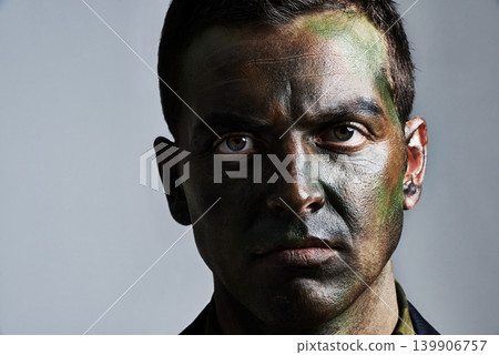Man, portrait and camouflage with face paint for war, battle or military service on a gray studio background. Closeup of male person, army or solider with color dye for undercover disguise on mockup Man, portrait and camouflage with face paint for war, battle or military service on a gray studio background. Closeup of male person, army or solider with color dye for undercover disguise on mockup 139906757