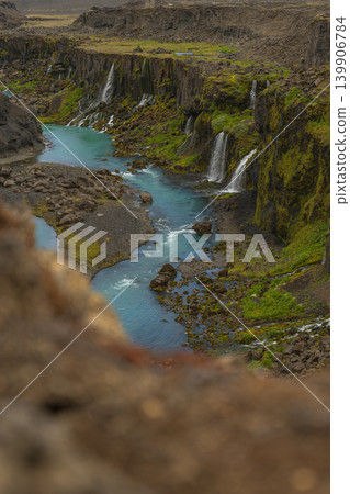 Steep Moss Covered Canyon with Turquoise River and Waterfalls in Iceland 139906784
