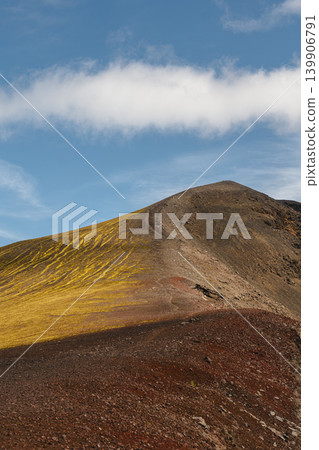 Rugged Icelandic Mountain with Volcanic Soil and Moss Under Blue Sky Rugged Icelandic Mountain with Volcanic Soil and Moss Under Blue Sky 139906791