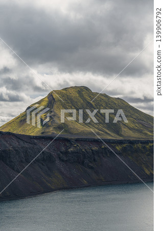 Green Covered Mountain with Ridge Reflected in Calm Water in Iceland Green Covered Mountain with Ridge Reflected in Calm Water in Iceland 139906792