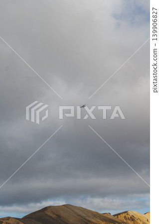 Helicopter Flying Over Rugged Hills in Iceland's Volcanic Terrain Helicopter Flying Over Rugged Hills in Iceland's Volcanic Terrain 139906827