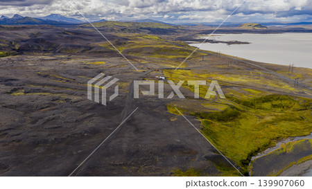 Aerial View of Volcanic Landscape with Road, Lake, and Buildings in Iceland Aerial View of Volcanic Landscape with Road, Lake, and Buildings in Iceland 139907060