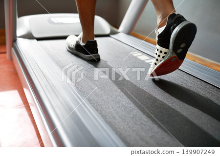 Fitness, feet and person running on treadmill in gym for health, wellness and body training. Active, shoes and closeup of athlete with workout or exercise on cardio machine at sports center. 139907249