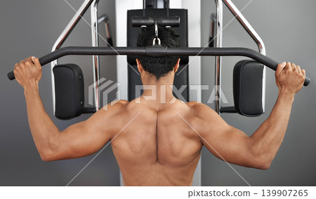 Exercise, pull down machine and man in studio on gray background for training or workout at gym. Back, health or shoulder press and body builder with equipment for wellness, strength or power Exercise, pull down machine and man in studio on gray background for training or workout at gym. Back, health or shoulder press and body builder with equipment for wellness, strength or power 139907265