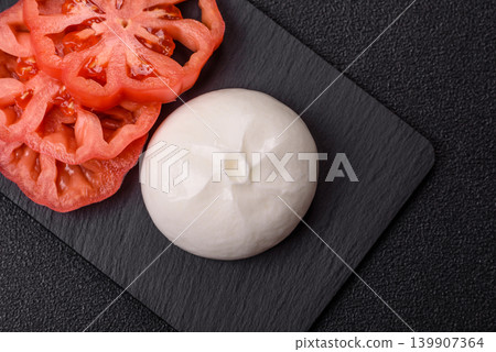 Fresh white burrata cheese with tomatoes for a salad. Burrata cheese Fresh white burrata cheese with tomatoes for a salad. Burrata cheese 139907364