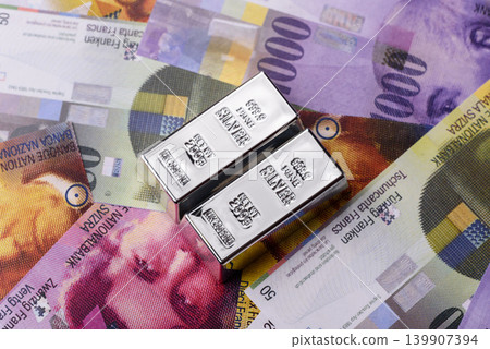 A silver bar, white metal against a backdrop of Swiss flag, as a concept for the sales. A silver bar A silver bar, white metal against a backdrop of Swiss flag, as a concept for the sales. A silver bar 139907394