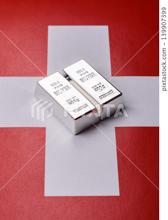A silver bar, white metal against a backdrop of Swiss flag, as a concept for the sales. A silver bar A silver bar, white metal against a backdrop of Swiss flag, as a concept for the sales. A silver bar 139907399