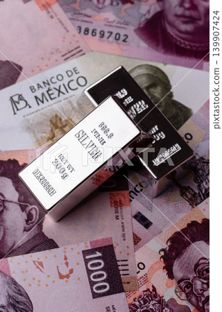 A silver bar, white metal against a backdrop of Mexican money, concept for the sales market A silver bar, white metal against a backdrop of Mexican money, concept for the sales market 139907424
