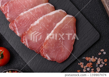 Smoked or dry cured meat slices, pork or ham with salt and spices. Smoked meat slices Smoked or dry cured meat slices, pork or ham with salt and spices. Smoked meat slices 139907474