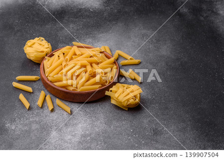 Italian uncooked dry penne regate pasta ready for cooking. Dry penne pasta 139907504