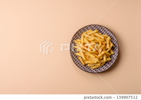 Crispy, fresh, golden French fries with salt, unhealthy takeaway food. French fries 139907512