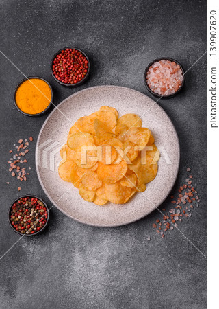 Crispy potato chips, golden slices seasoned with salt and spices. Potato chips Crispy potato chips, golden slices seasoned with salt and spices. Potato chips 139907620