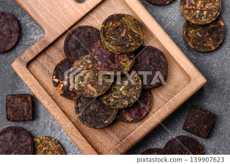 Organic Chinese green pu-erh tea with various herbs in round bricks. Chinese pu-erh tea Organic Chinese green pu-erh tea with various herbs in round bricks. Chinese pu-erh tea 139907623