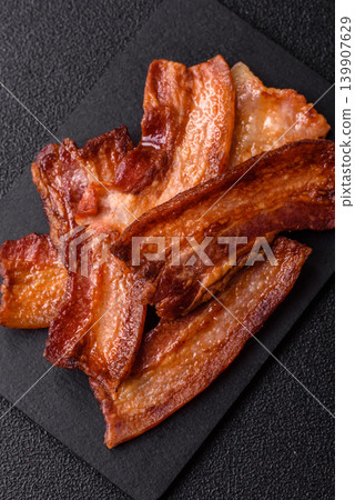Fried fresh bacon slices with layers of meat or prosciutto prepared for breakfast. Fried bacon 139907629