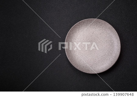 An empty ceramic round plate, kitchen utensils for a dinner table. An empty plate An empty ceramic round plate, kitchen utensils for a dinner table. An empty plate 139907648