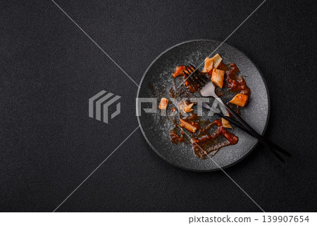 A dirty plate after a meal with leftover pasta and tomato sauce, cleaning. An empty dirty plate A dirty plate after a meal with leftover pasta and tomato sauce, cleaning. An empty dirty plate 139907654