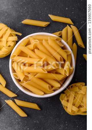 Italian uncooked dry penne regate pasta ready for cooking. Dry penne pasta Italian uncooked dry penne regate pasta ready for cooking. Dry penne pasta 139907660
