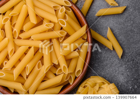 Italian uncooked dry penne regate pasta ready for cooking. Dry penne pasta Italian uncooked dry penne regate pasta ready for cooking. Dry penne pasta 139907664