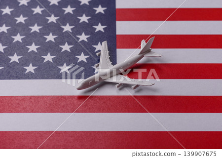 An airplane on the US flag as a conceptual backdrop for flights and travel. An airplane on the flag 139907675