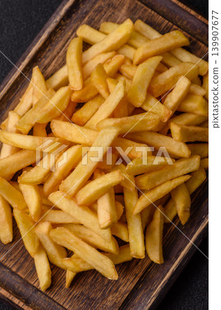 Crispy, fresh, golden French fries with salt, unhealthy takeaway food. French fries Crispy, fresh, golden French fries with salt, unhealthy takeaway food. French fries 139907677