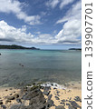 A beautiful gradient of ocean colors and a sandy beach with rocky outcrops. 139907701