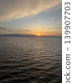 A view of the sunset over the sea and the twilight sky. 139907703
