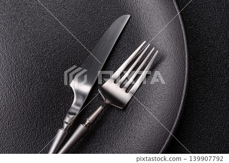 An empty ceramic round plate, kitchen utensils for a dinner table. An empty plate An empty ceramic round plate, kitchen utensils for a dinner table. An empty plate 139907792