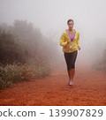 Woman, health and running in forest with fitness for exercise, morning routine and workout with fog and confidence. Athlete, person and cardio with sportswear on outdoor trail and woods for wellness 139907829