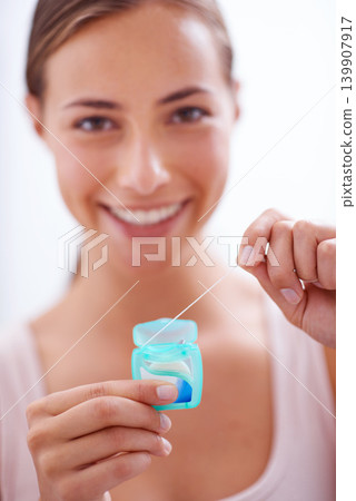Portrait, smile and dental floss for oral hygiene care with woman in bathroom of home for teeth whitening. Face, product and happy young person in apartment to prevent tooth decay or gum disease Portrait, smile and dental floss for oral hygiene care with woman in bathroom of home for teeth whitening. Face, product and happy young person in apartment to prevent tooth decay or gum disease 139907917