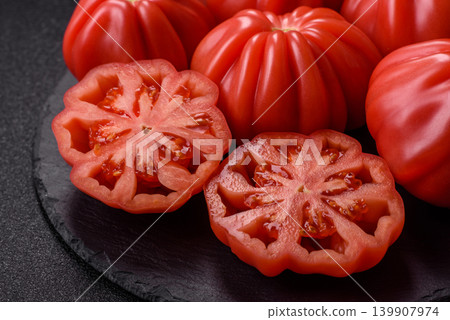 Fresh pink heirloom ribbed tomatoes as an ingredient for a lunch salad. Ribbed heirloom tomatoes Fresh pink heirloom ribbed tomatoes as an ingredient for a lunch salad. Ribbed heirloom tomatoes 139907974