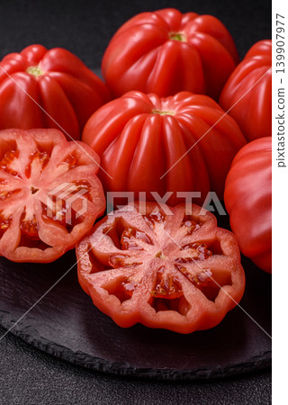 Fresh pink heirloom ribbed tomatoes as an ingredient for a lunch salad. Ribbed heirloom tomatoes Fresh pink heirloom ribbed tomatoes as an ingredient for a lunch salad. Ribbed heirloom tomatoes 139907977