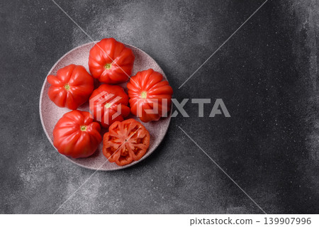 Fresh pink heirloom ribbed tomatoes as an ingredient for a lunch salad. Ribbed heirloom tomatoes Fresh pink heirloom ribbed tomatoes as an ingredient for a lunch salad. Ribbed heirloom tomatoes 139907996