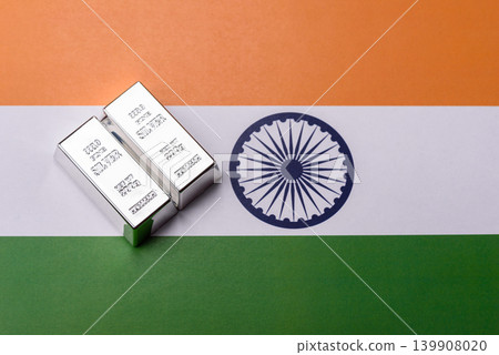 A silver bar, white metal against a backdrop of Indian flag, as a concept. A silver bar A silver bar, white metal against a backdrop of Indian flag, as a concept. A silver bar 139908020
